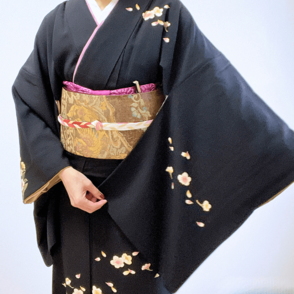 黒地に桜柄の訪問着に鳳凰柄の袋帯を合わせたコーディネイト。